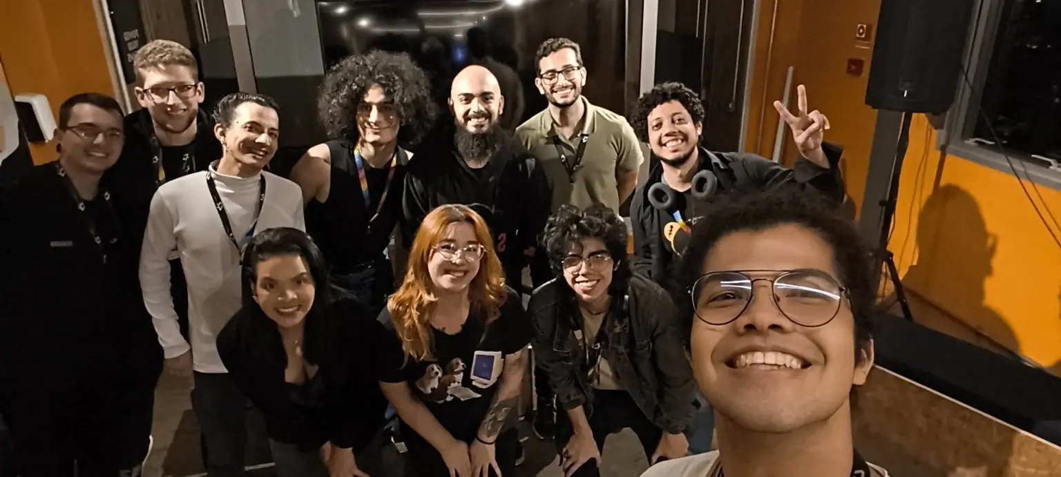Selfie de um grupo sorridente no fim de um meetup
